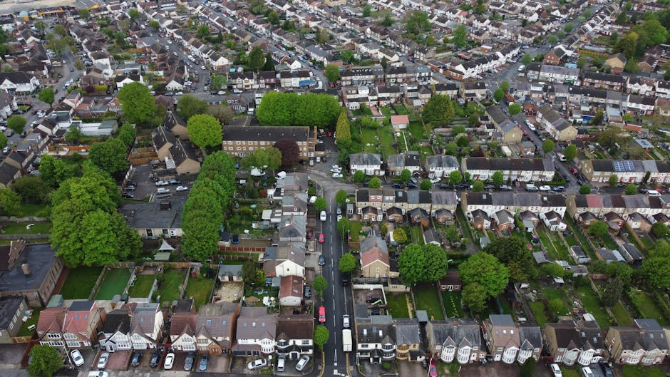An aerial view of a residential neighbourhood featuring small front gardens and well-maintained hedges. The image shows a variety of houses with different architectural styles, some with bay windows a